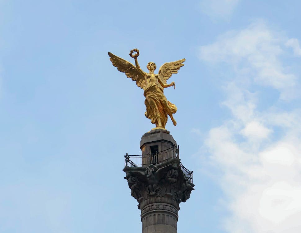 El dorado Ángel de la Independencia se alza contra un cielo azul sobre Paseo de la Reforma en la Ciudad de México