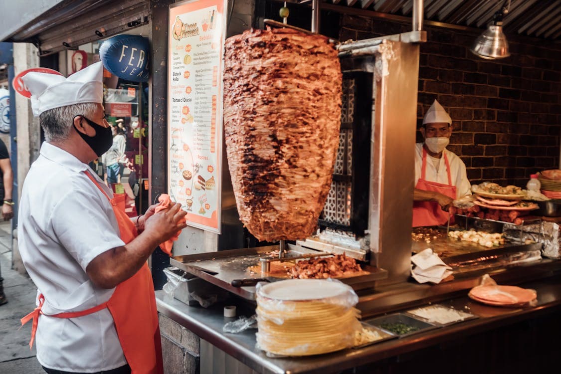 Un taquero prepara tacos al pastor en un puesto de comida callejera en la Ciudad de México